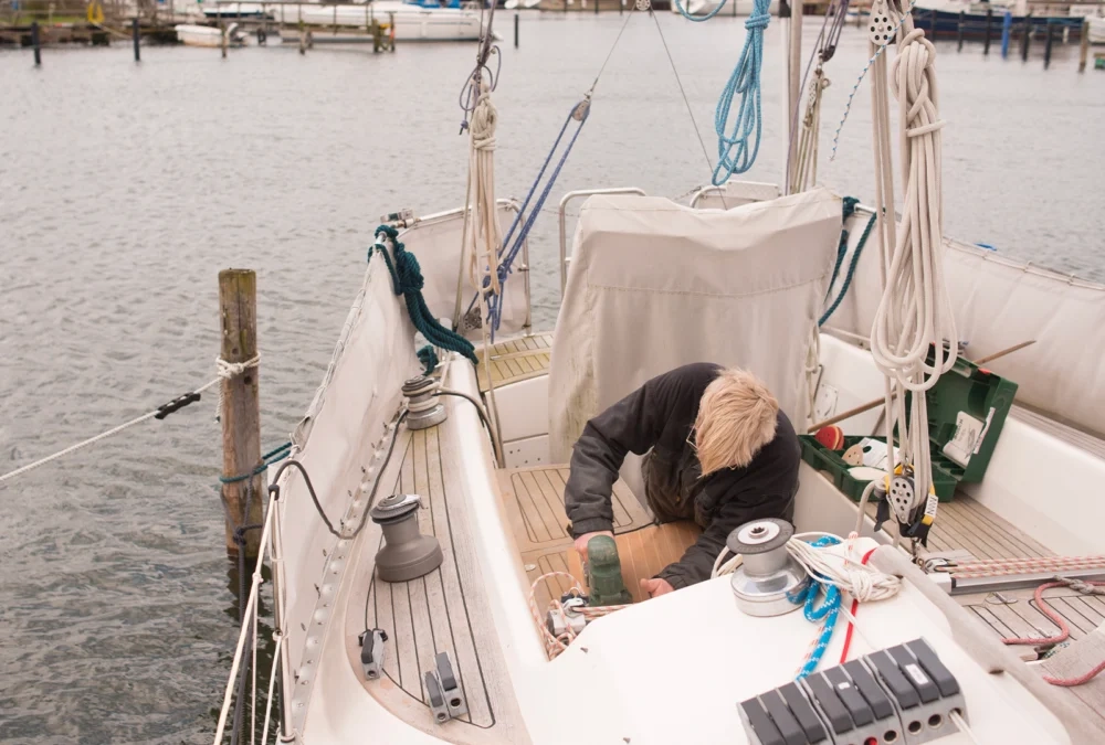 Crew member working on the foredeck of a moored sailing yacht