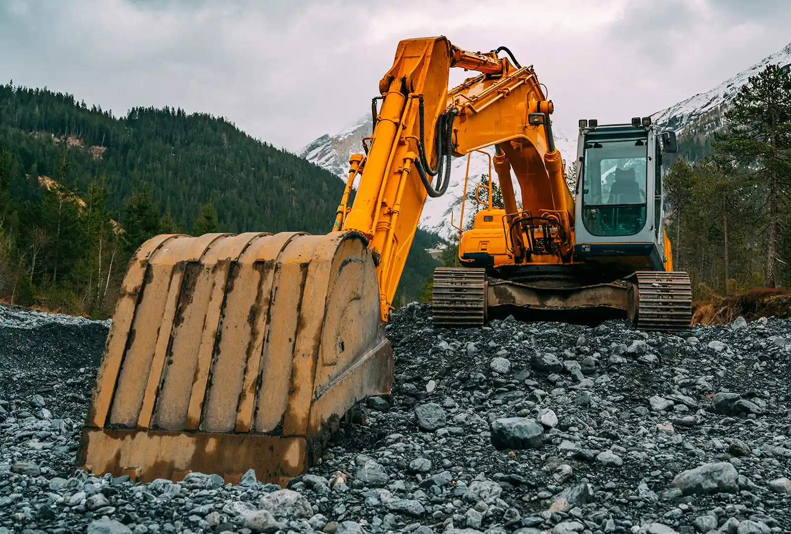 Excavators working on a rocky site in the mountains
