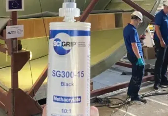 SCIGRIP SG300-15 Black cartridge held up in front of workers bonding a structure