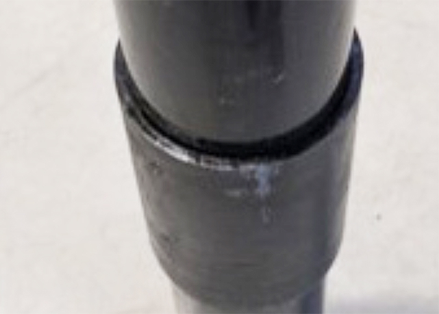 Close-up of a bonded joint between two sections of black composite pipe