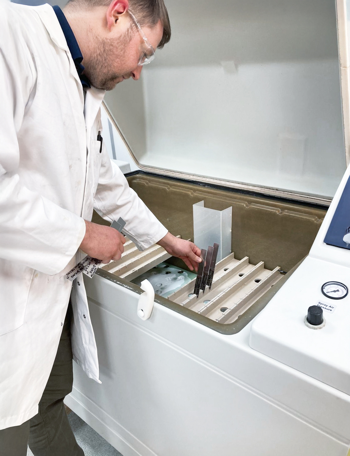 Technician loading bonded test strips into a laboratory test chamber